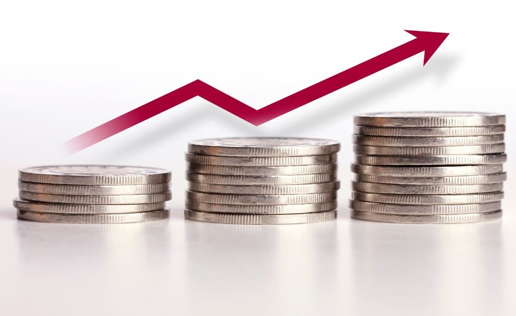 Stack of coins with an upward trend line representing rising healthcare inflation.