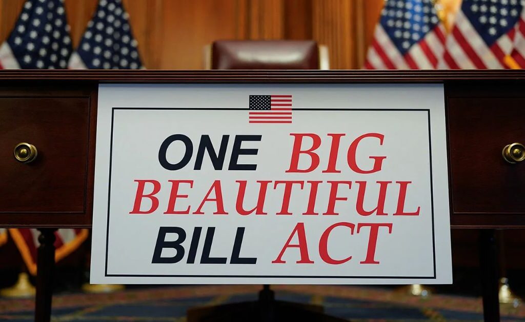 Sign reading "One Big Beautiful Bill Act" at a government hearing, representing new federal healthcare legislation.